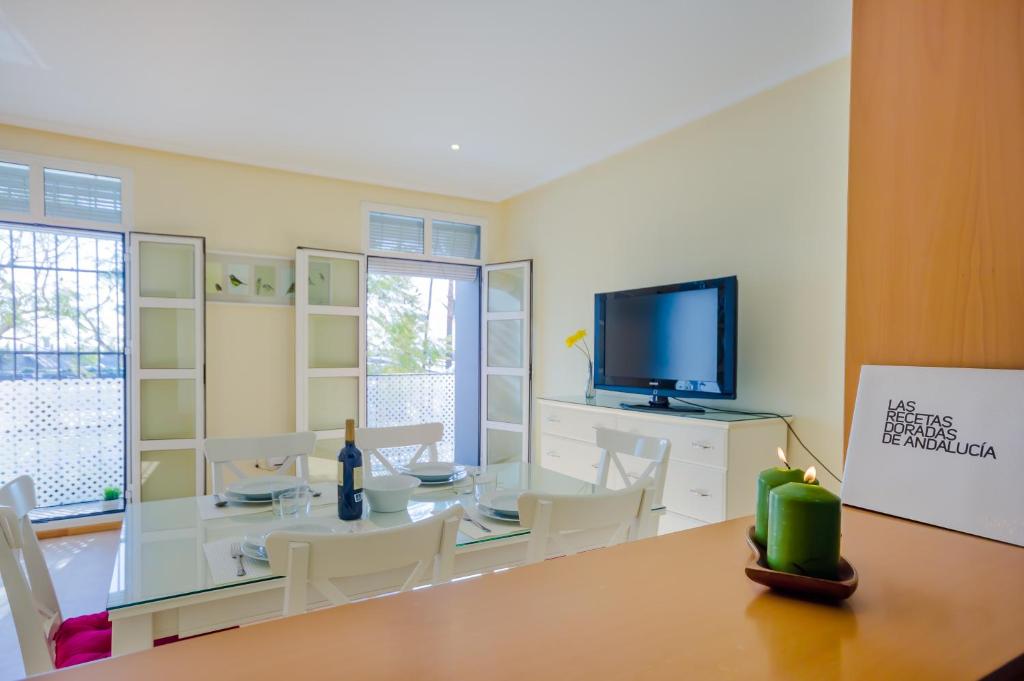 圣玛丽亚港Apartamentos Ribera del Puerto的一间带桌子和平面电视的用餐室