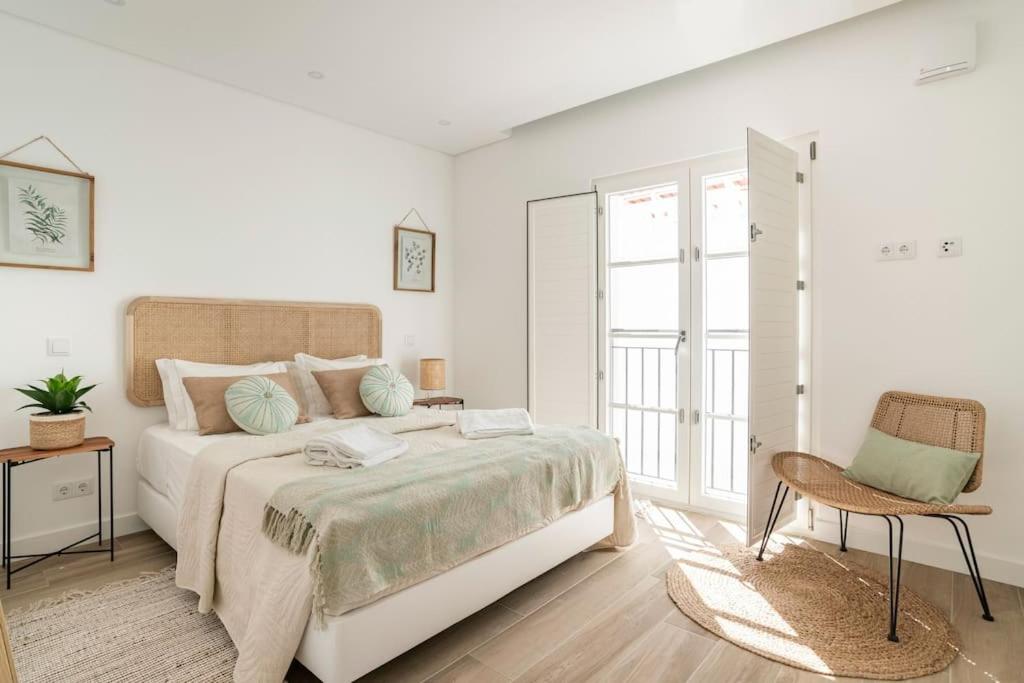 奥良Casa Nova do Levante, perto do Mar的白色卧室配有床和椅子