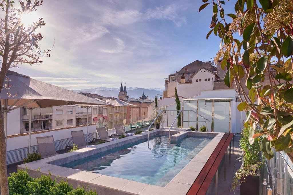 格拉纳达Boutique Hotel Luna Granada Centro的建筑物屋顶上的游泳池