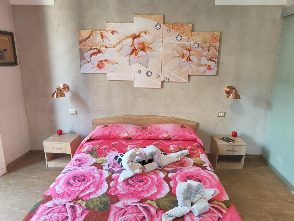 卡塔尼亚Pantaleone Holiday House的卧室配有粉红色玫瑰花粉色床