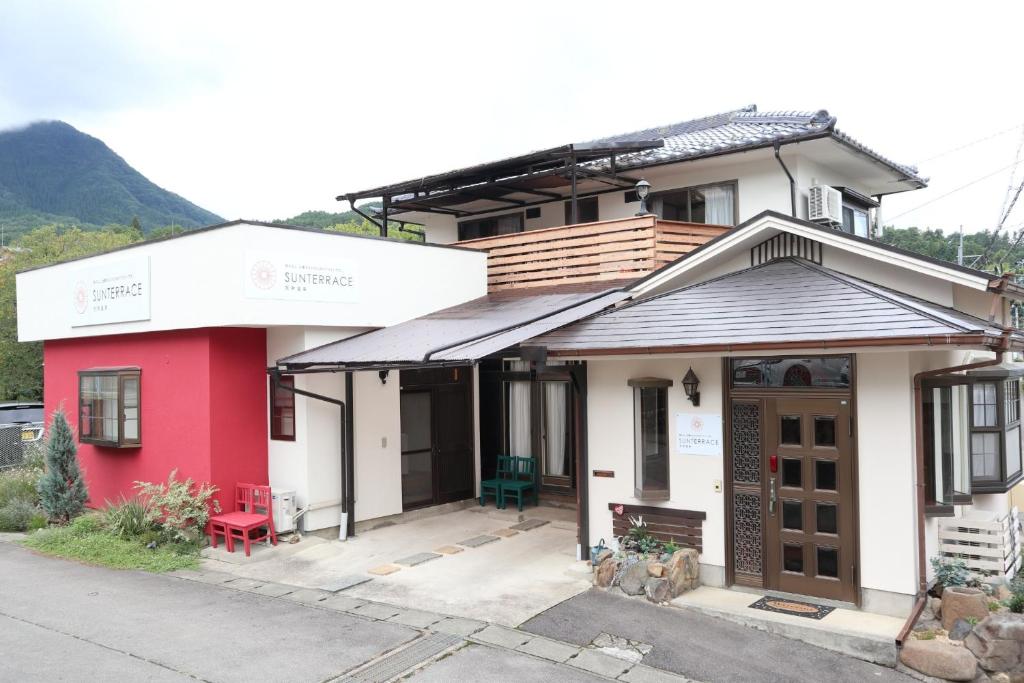 上田市Sun Terrace Bessho Onsen - Vacation STAY 21387v的前面有红色长凳的红白色房子