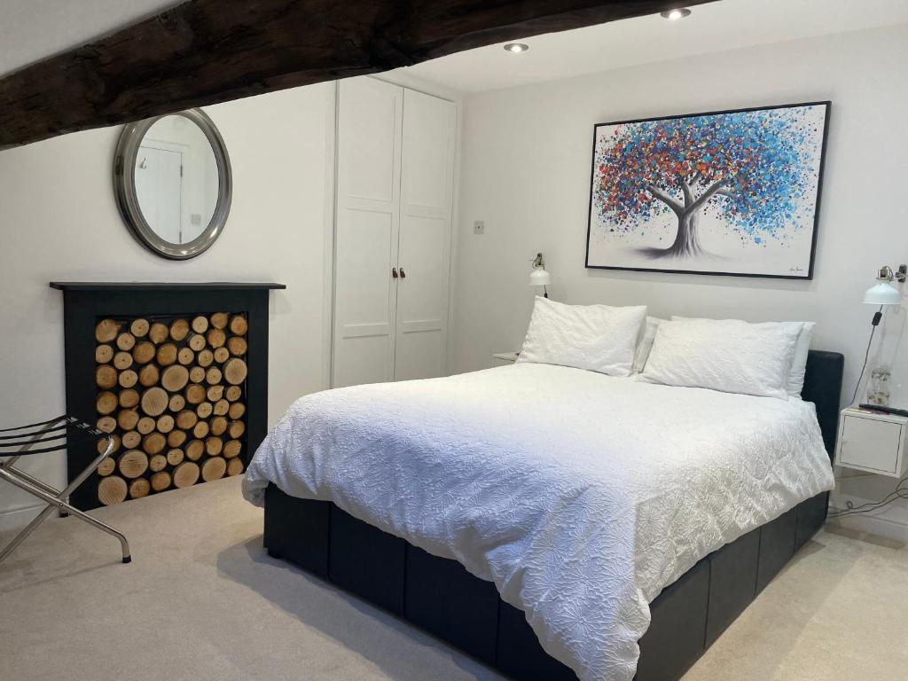 康格尔顿Dove House的卧室配有一张床,墙上挂着一幅树画