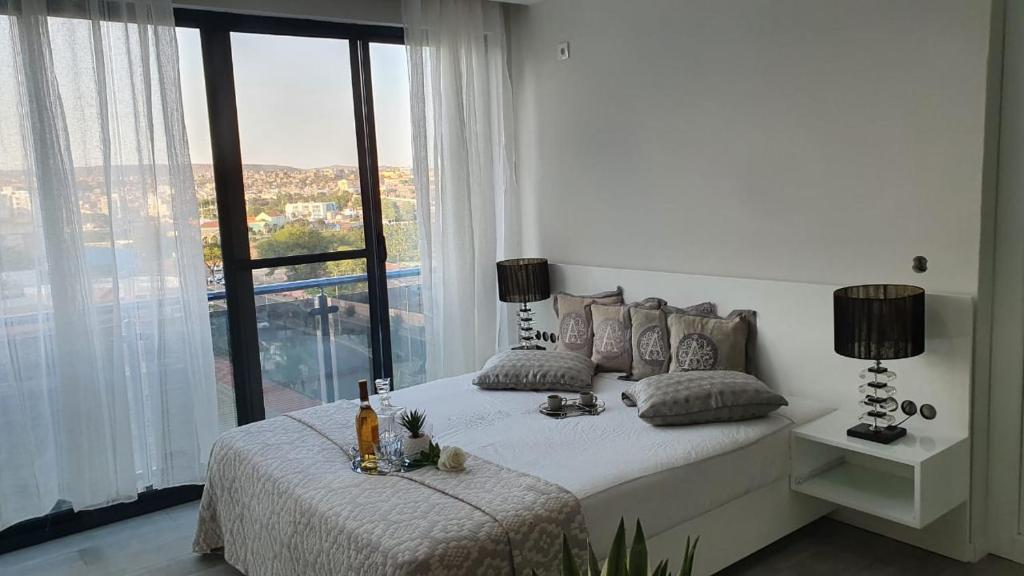 普拉亚Cazinos Apartamento的白色的卧室设有床和大窗户