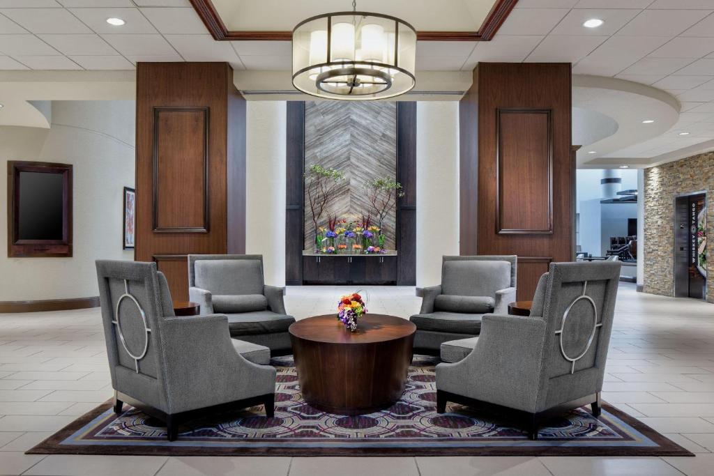 欧文喜来登DFW机场酒店的大堂设有椅子、桌子和吊灯。