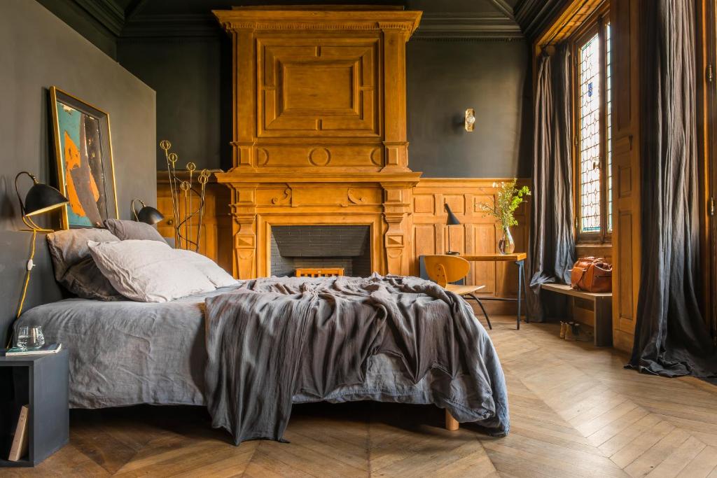 圣马丹德雷LE SECRET的一间卧室配有一张床和一个壁炉