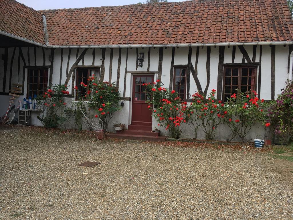 DominoisBaie de Somme Villa gros Becs的前面有红花的白色房子