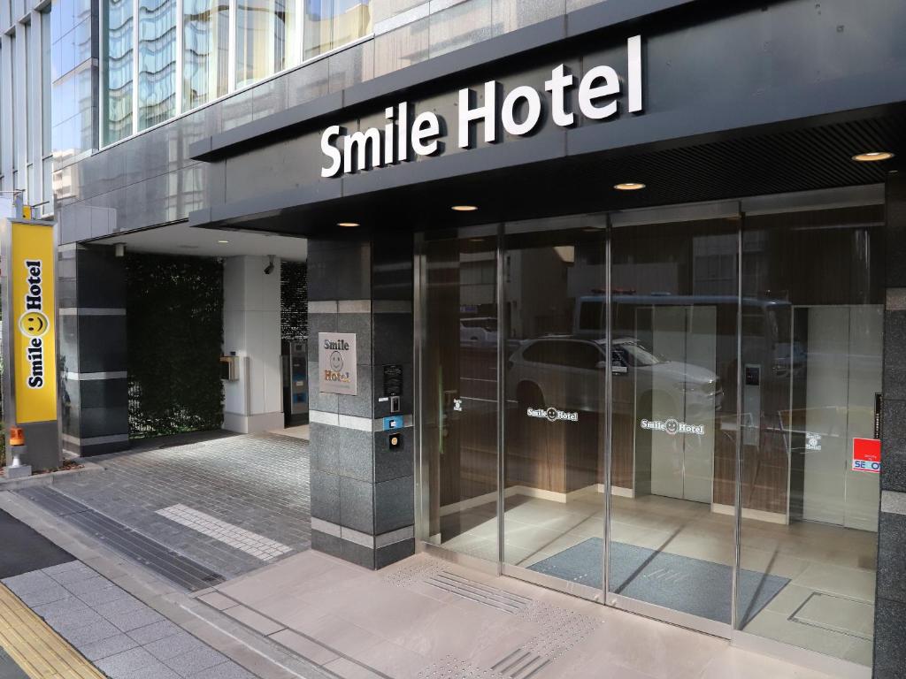 东京Smile Hotel Shinagawasengakujiekimae的大楼一侧的微笑酒店标志