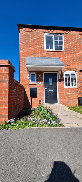 Wishart Drive的砖砌的建筑,前面有一扇门,鲜花盛开