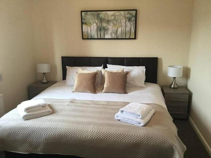 斯肯索普Park Cottage的一间卧室配有一张大床和毛巾