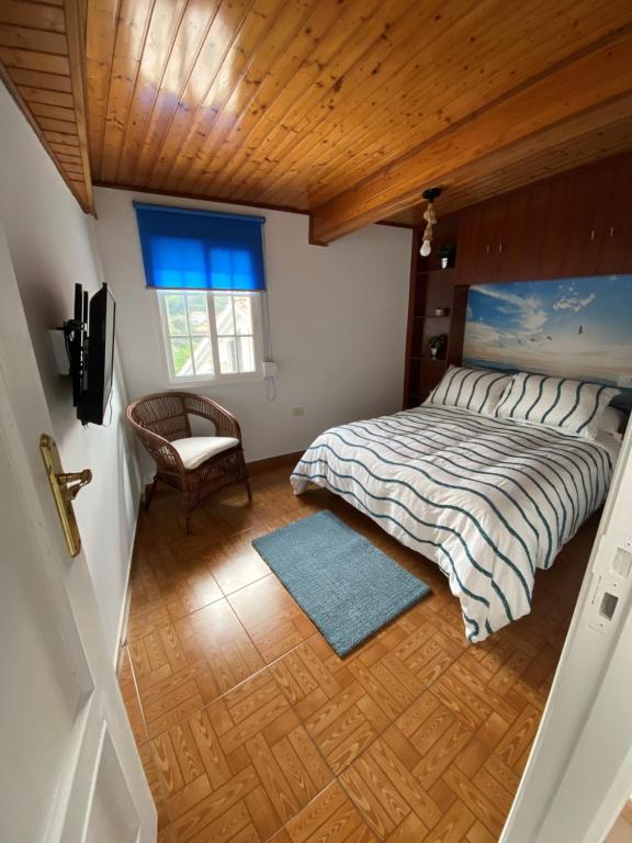 布埃乌Bueu的卧室配有床、椅子和窗户。