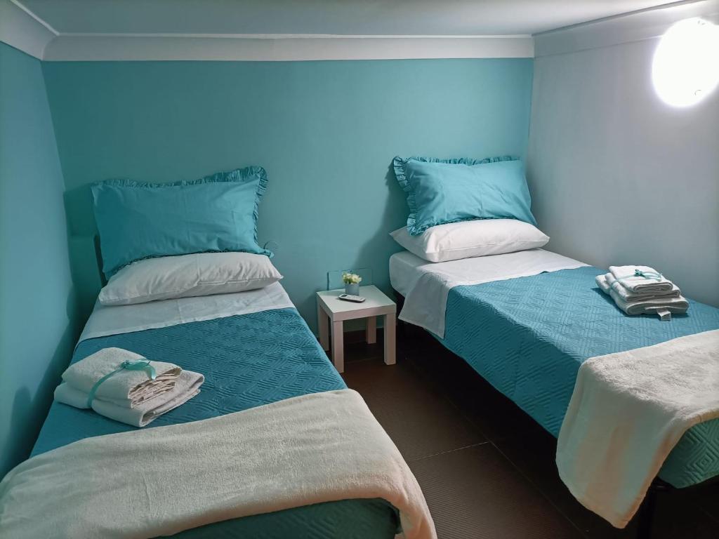 那不勒斯Napoli nel cuore的蓝色墙壁客房的两张床