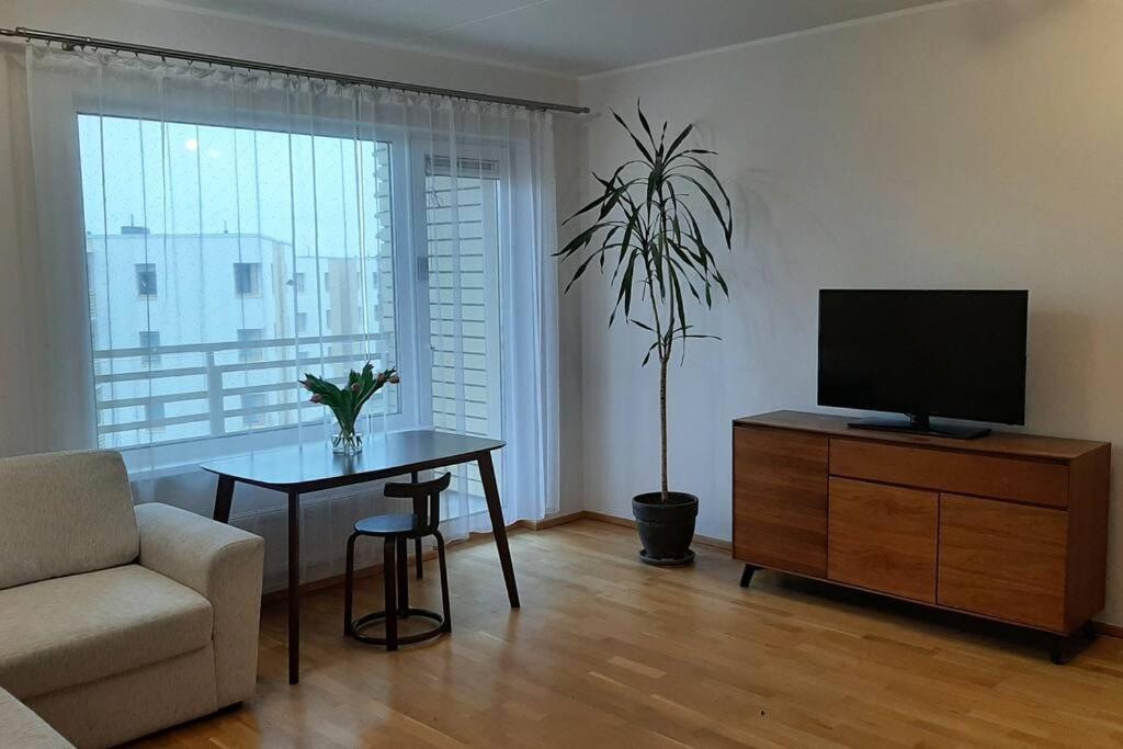 塔林Puhas 2 toaline Kakumäe korter的客厅配有电视、桌子和椅子