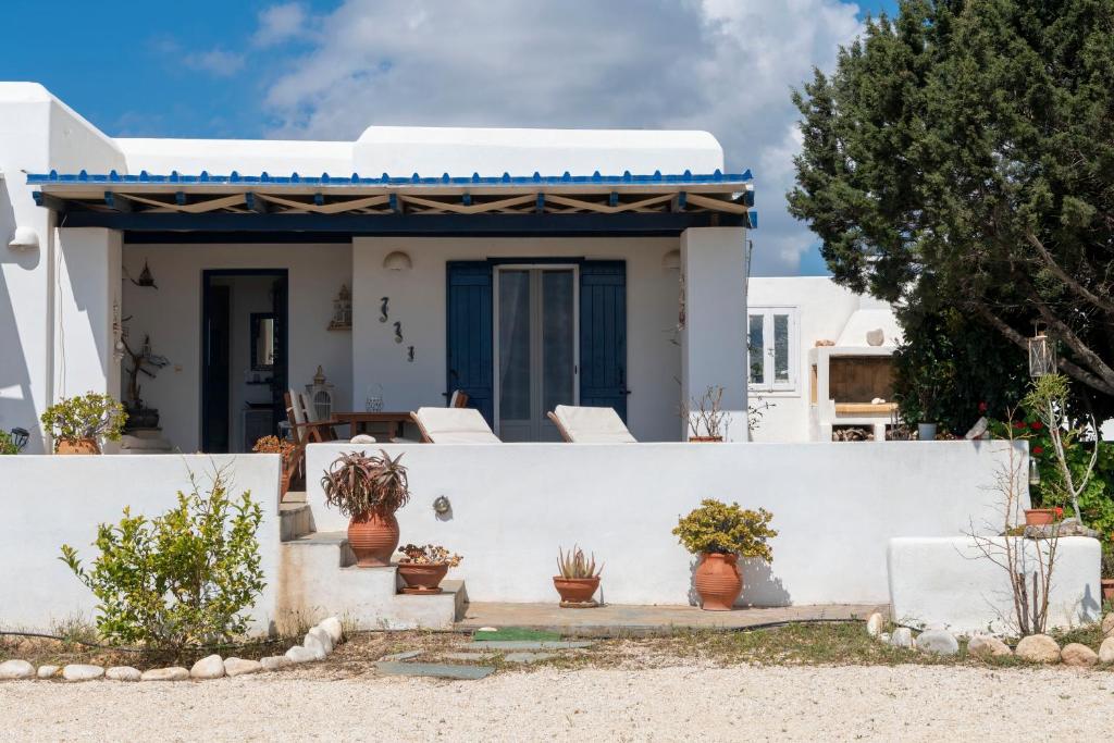 帕罗斯岛Cycladic home in Paros的白色的房子,拥有白色的墙壁和白色的椅子