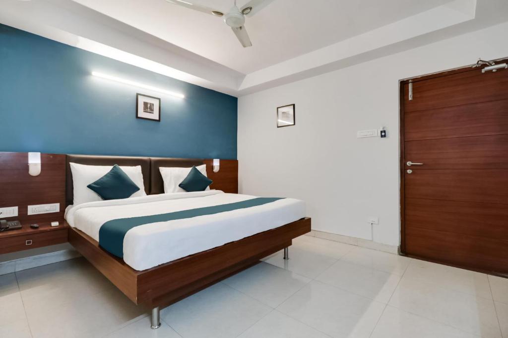AlipurHotel Stay Inn Maharani Peta的一间卧室设有一张蓝色墙壁的大床