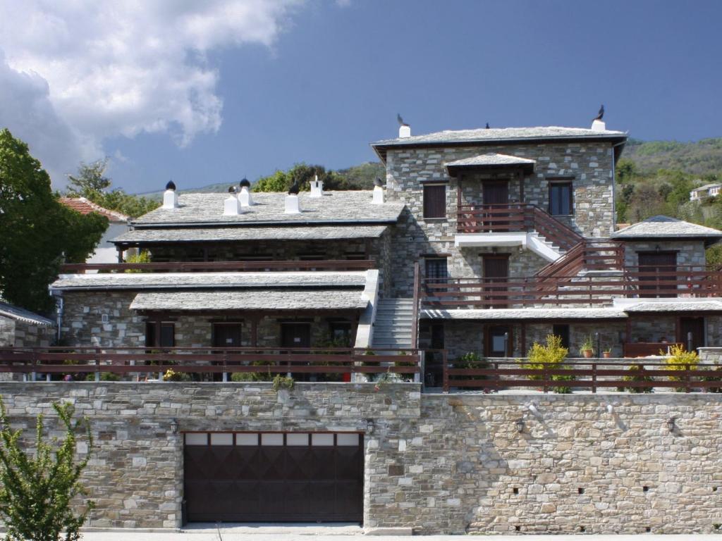米莱艾Anemoessa Traditional Guesthouse的石墙顶上的一座大型石屋