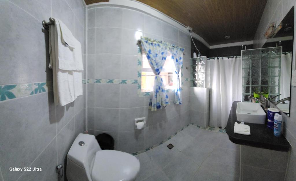 LibagonCHUE&LARRY'S BEACHSIDE HOMESTAY的一间带卫生间、水槽和窗户的浴室