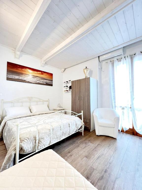 奥斯图尼Il Girasole的白色卧室配有床和椅子