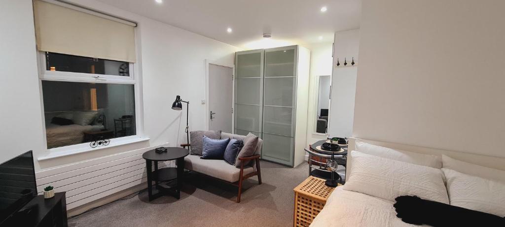 伦敦Maple House - Inviting 1-Bed Apartment in London的卧室配有床、椅子和窗户。