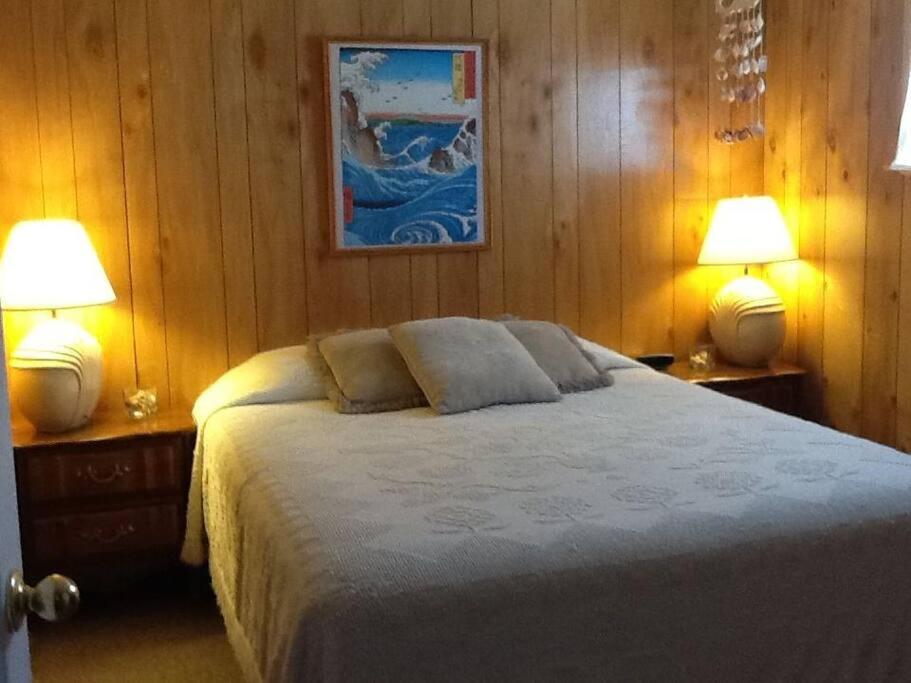 莫罗贝Suite Breeze Beach Vacation Rental - one bedroom apartment.的一间卧室配有一张大床和两盏灯