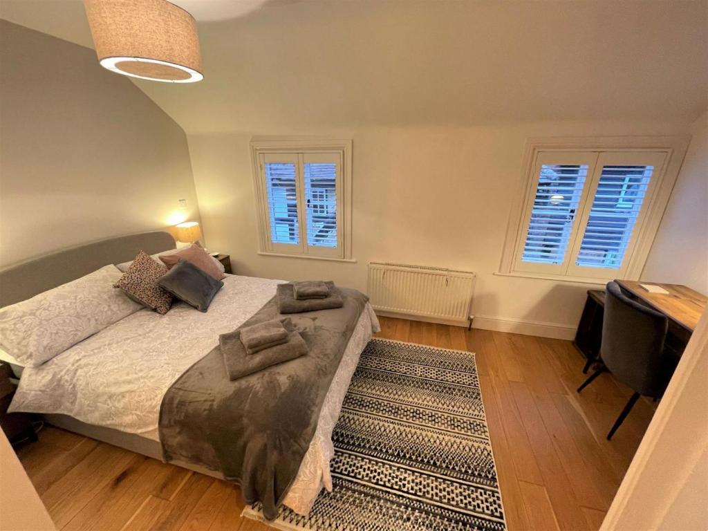 霍舍姆Peaceful Cottage for Two in Horsham的一间卧室设有一张大床和两个窗户。