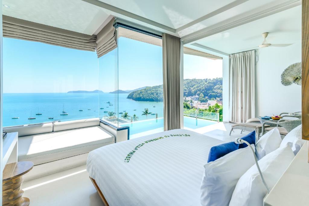 攀瓦海滩Bandara Villas, Phuket的一间卧室设有俯瞰大海的大窗户