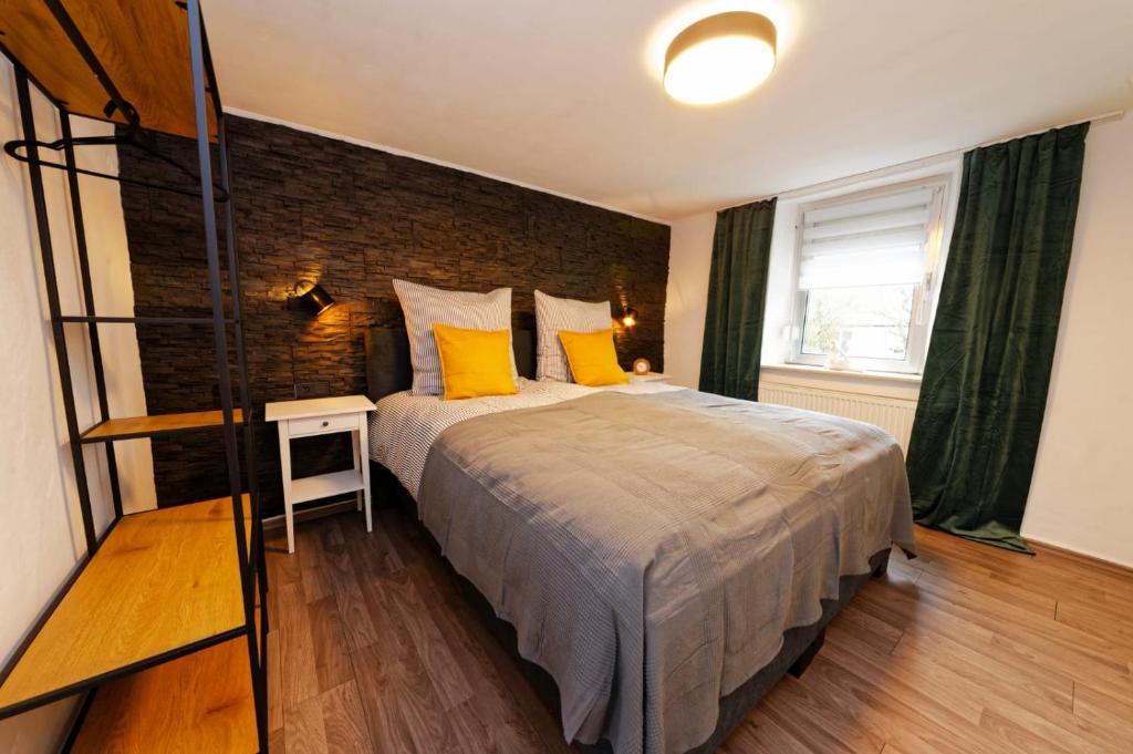 BeilingenCasa Eifel的一间卧室设有一张大床和砖墙