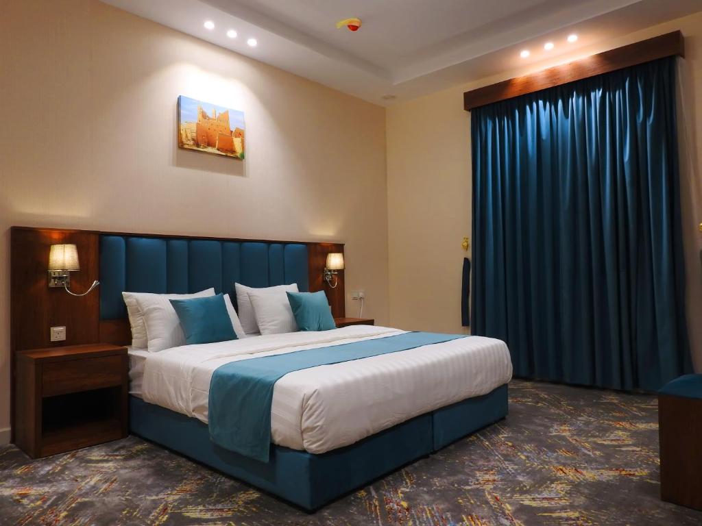 艾卜哈انباك للشقق المخدومه的一间卧室配有大床和蓝色窗帘