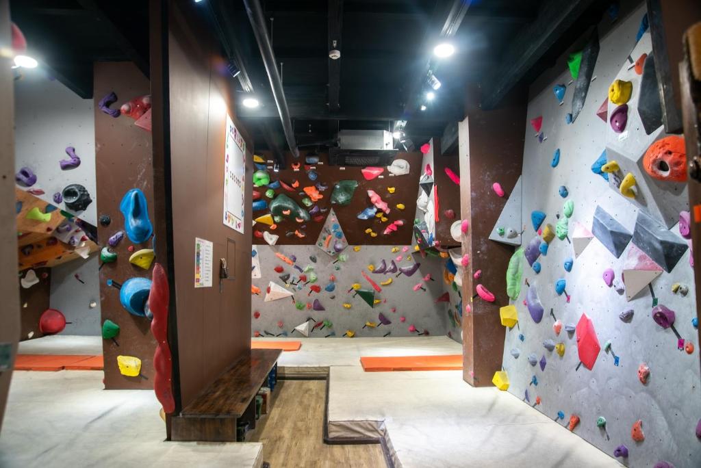 洲本市CLIMB INN COCOMO的一间带攀岩墙的房间和一个攀岩健身房