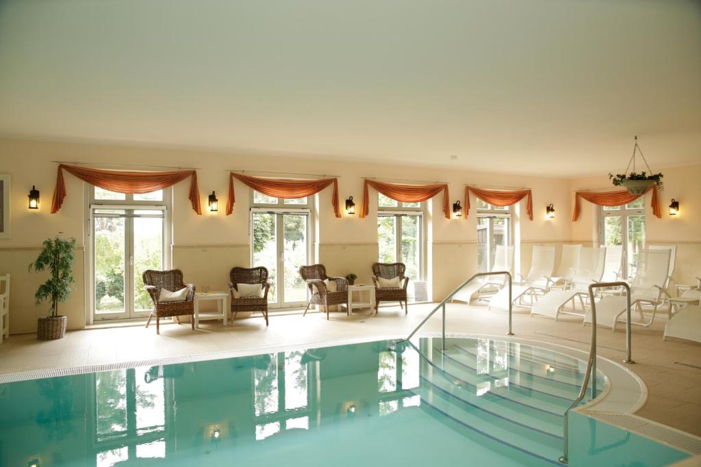 唐格明德坦哲蒙城堡酒店的一个带椅子的客厅内的大型游泳池
