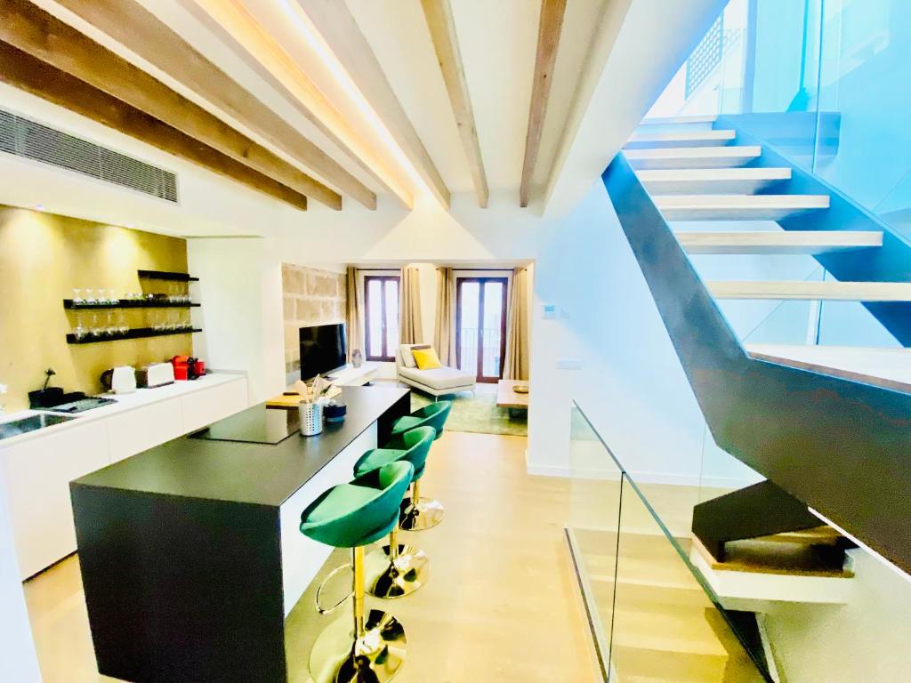 马略卡岛帕尔马Hotel-Apartment with big terrace的一个带楼梯和绿色椅子的大厨房