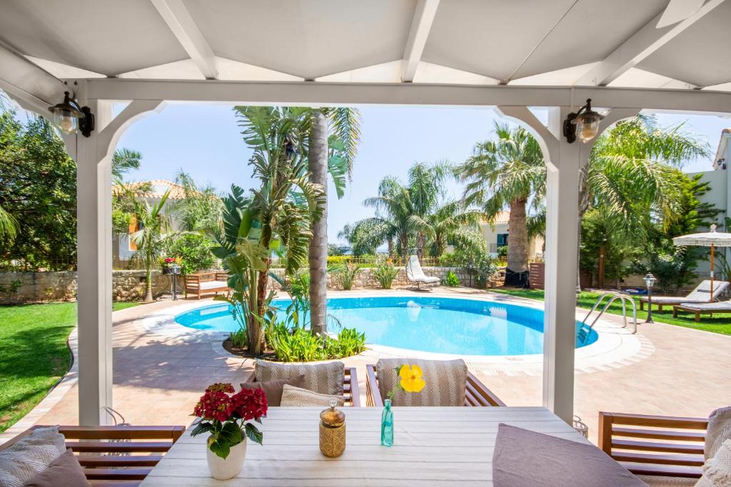 赫索尼索斯潘多拉别墅的一个带桌子和游泳池的庭院