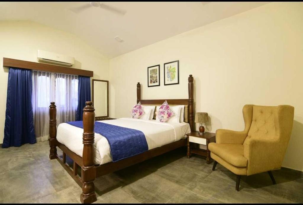阿伯来Townhouse OAK Arpora Villas Near Baga Beach的一间卧室配有一张床和一把椅子