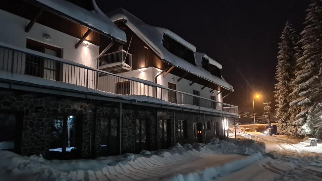 泽勒兹纳·鲁达多米尼克宾馆的一座晚上下雪的建筑