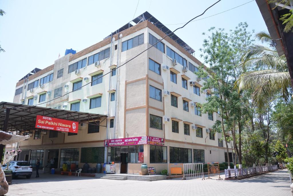 舍地HOTEL SAI PALKHI NIWARA的棕榈树街道上的建筑