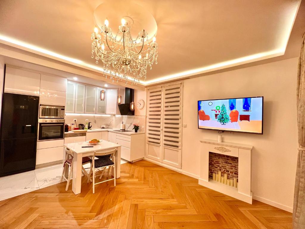 布瓦西圣雷热Alexandru Home的带壁炉的厨房以及墙上的电视。