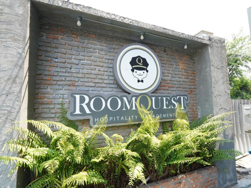 曼谷RoomQuest Bangkok Don Mueang Airport的砖楼边的标志