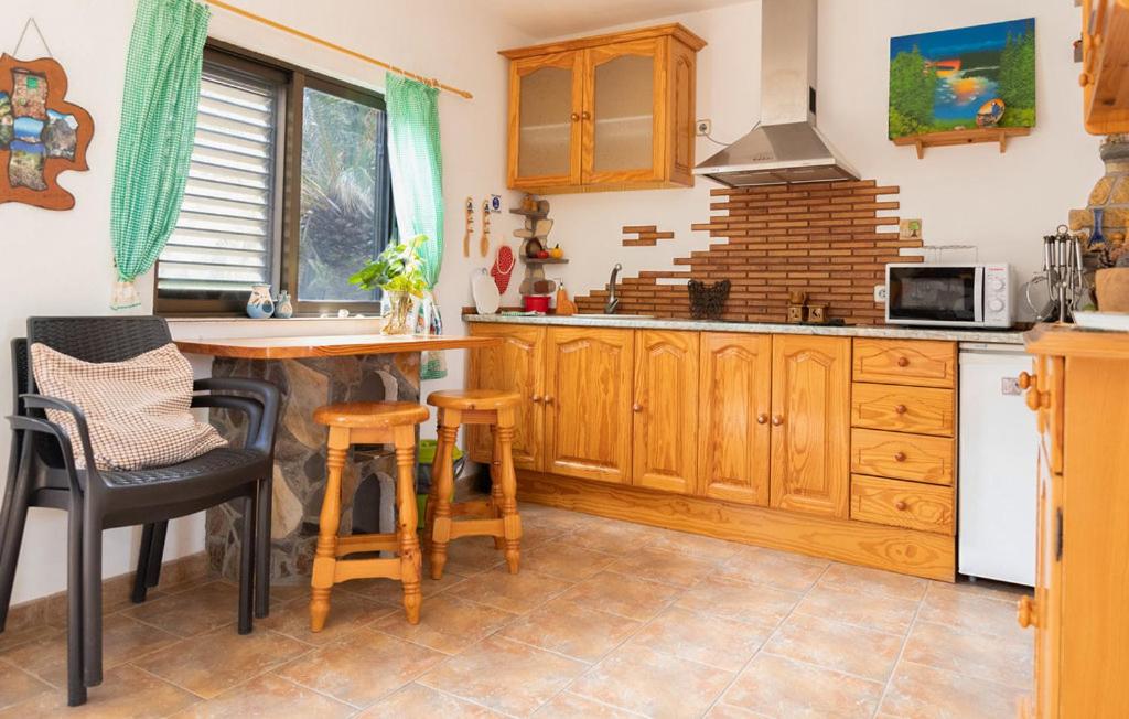 巴列埃尔莫索Casa GRENADO的厨房配有木制橱柜和桌椅