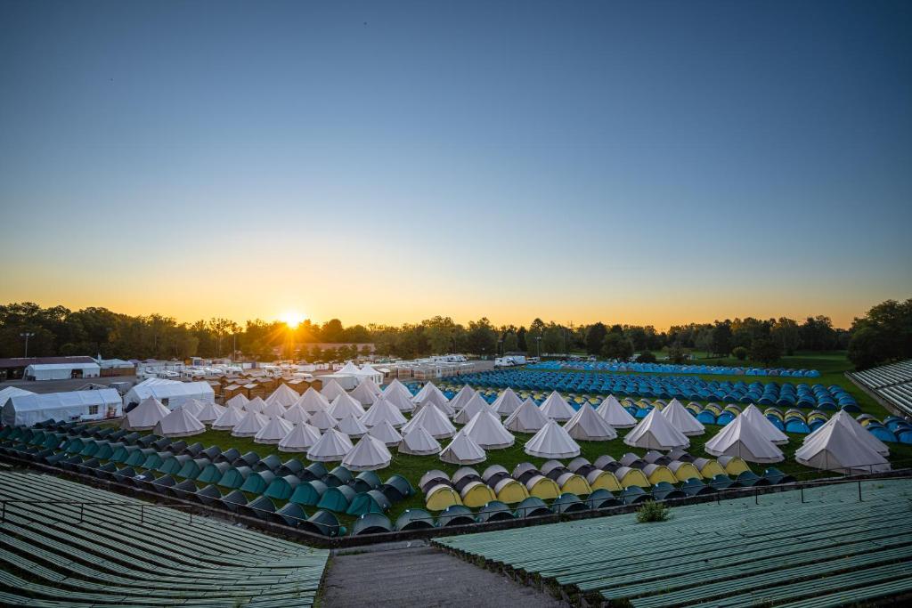 慕尼黑维斯露营地的一群白色的帐篷,在一片田野上,日落