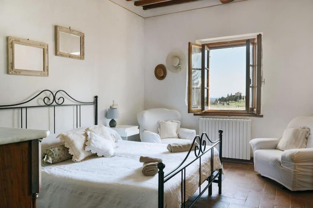 基安蒂盖奥勒Guest House il Gatto的一间卧室配有一张床、一张沙发和一个窗口