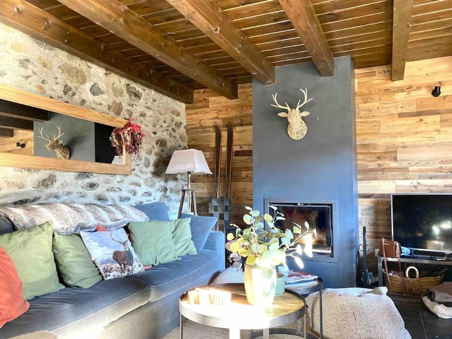 UrXalet Montana的客厅设有蓝色的沙发和石墙
