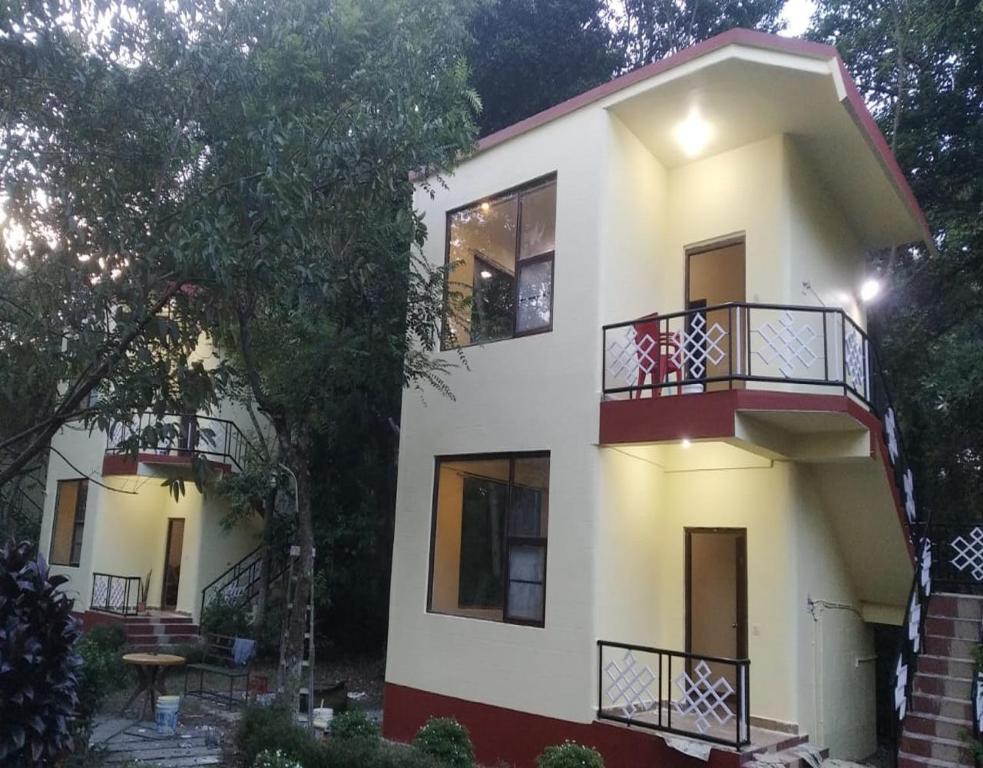 Uttar SimlabariNalgarh Retreat - JUNGLE RESORT by StayApart的白色房子的一侧设有阳台