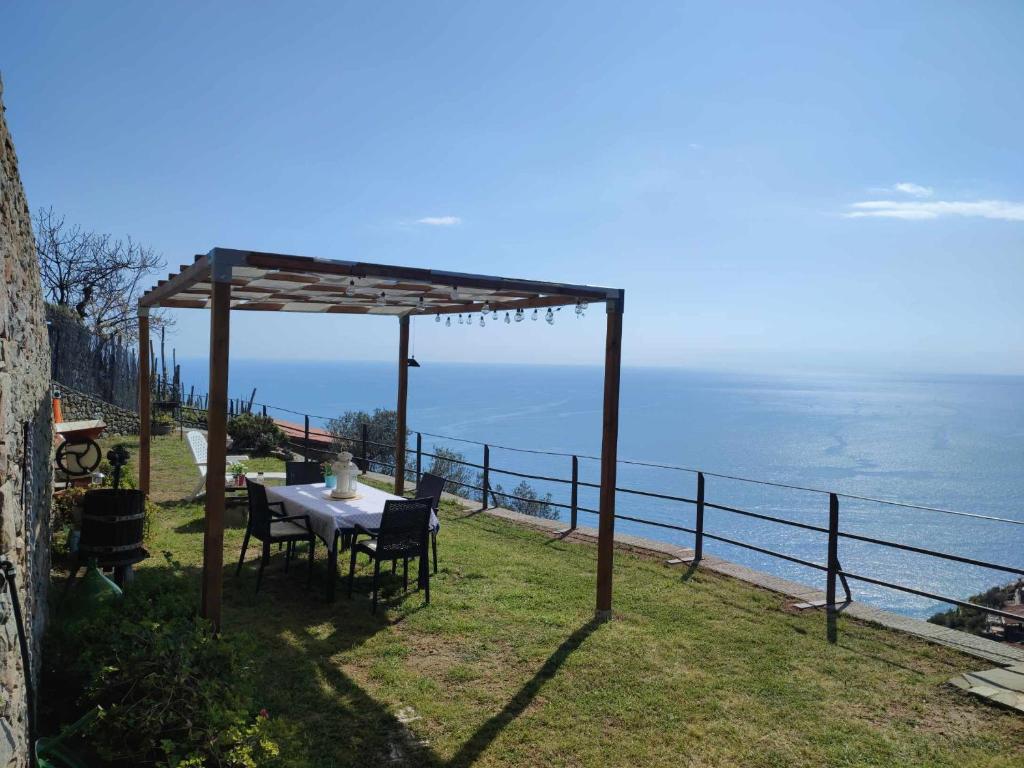 坎皮利亚马里蒂马Casa a picco sul mare 5 terre的凉亭下的桌椅,俯瞰着大海