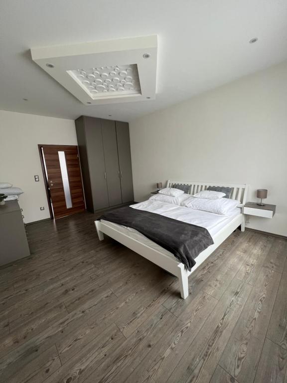 佐洛埃格塞格Geri Imádnivaló lakás Zalaegerszeg belvárosában的卧室配有一张白色的大床,铺有木地板