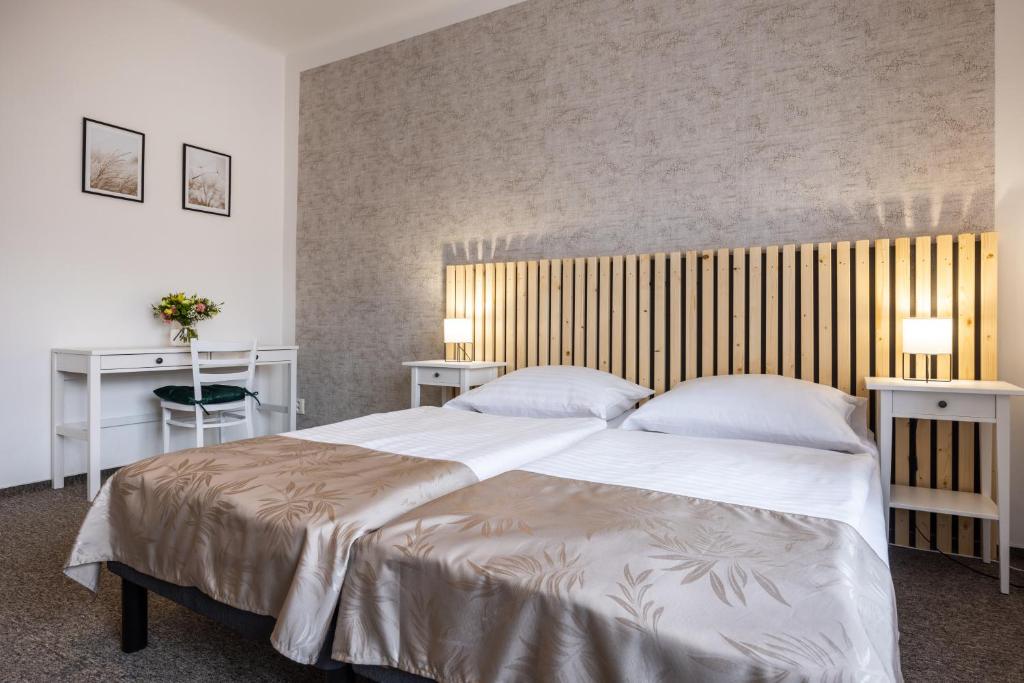 利托米什尔塔西耐尔旅馆的卧室配有一张带两张桌子的大型白色床