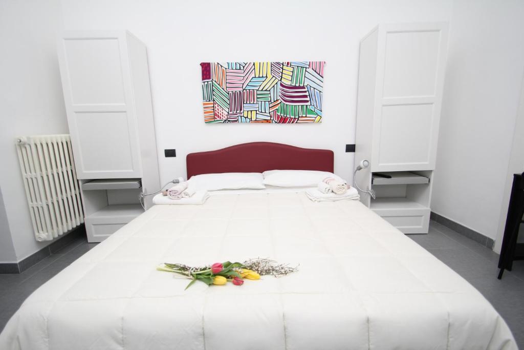 阿韦利诺Angoletto Young B&B的卧室配有一张白色大床,墙上挂有绘画作品
