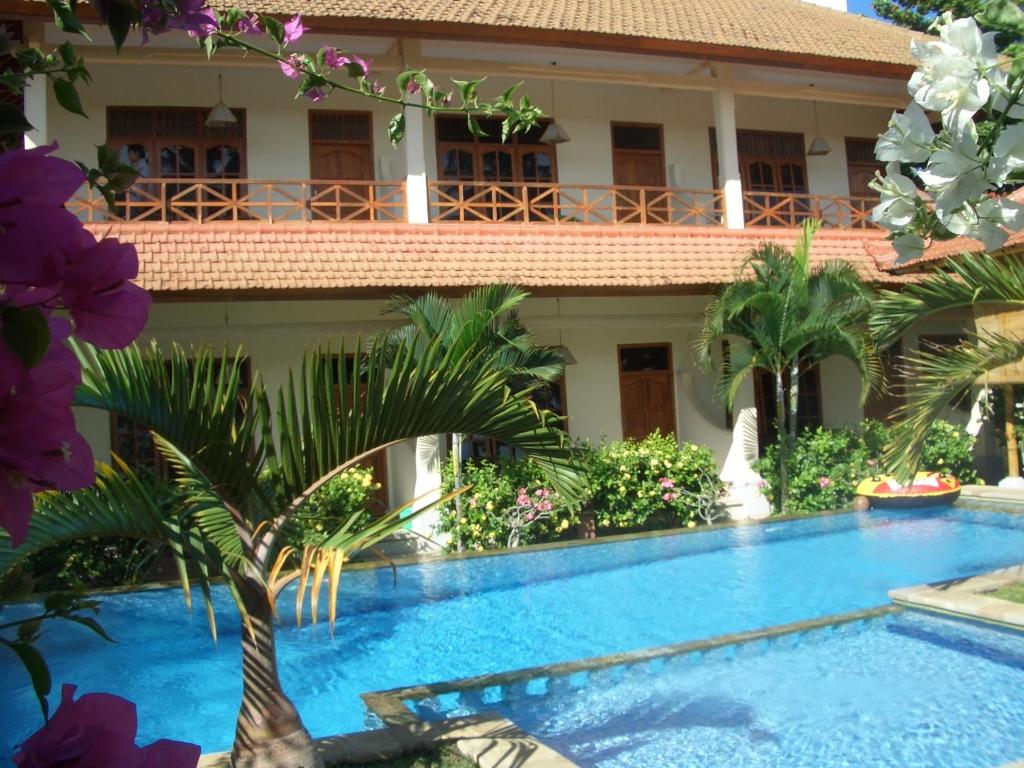 罗威那贾耶旅馆的一座带游泳池的度假村,位于一座建筑前