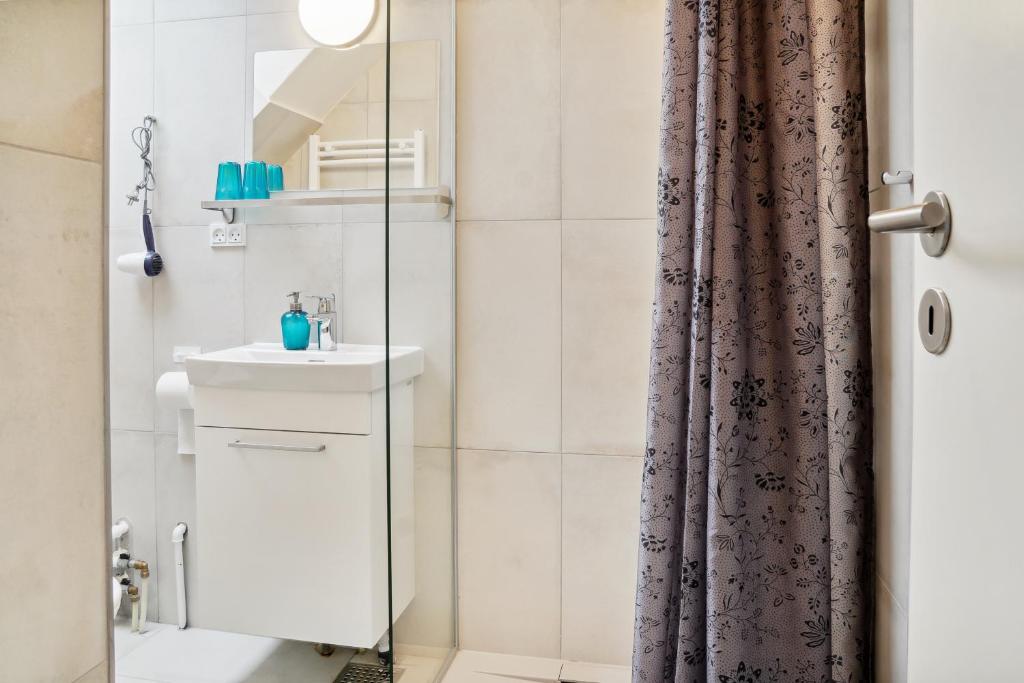 哥本哈根NICE TOPFLOOR STUDIO APARTMENT的浴室配有淋浴帘和盥洗盆。