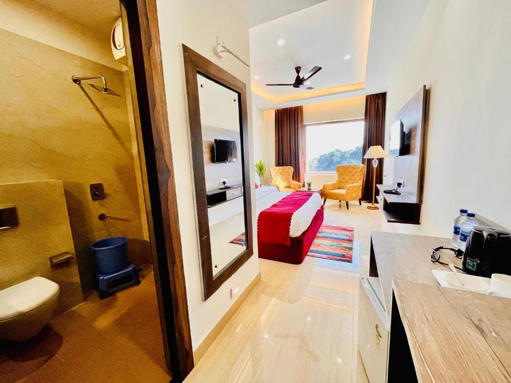 哈里瓦Ganges blossam - A Four Star Luxury Hotel & Resort的酒店客房设有浴室和卧室