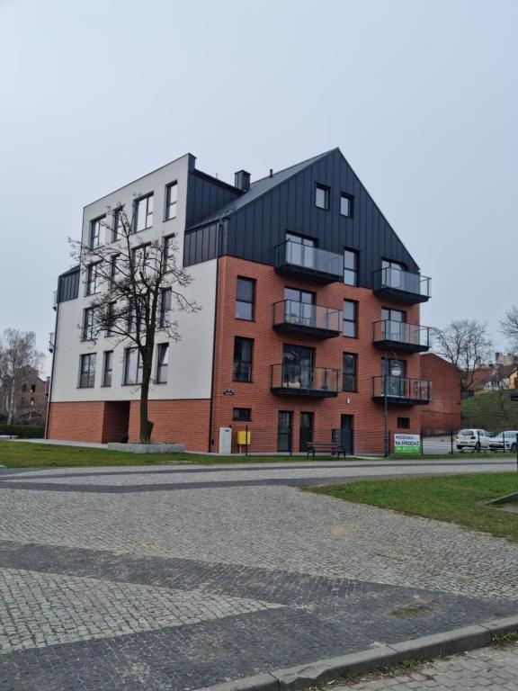 特切夫Apartament Nad Wisłą的公寓大楼设有黑色屋顶