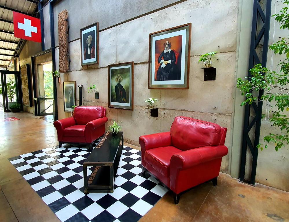 圣克鲁斯Alfonsina Hotel Boutique的客厅设有2把红色椅子和1个 ⁇ 格地板
